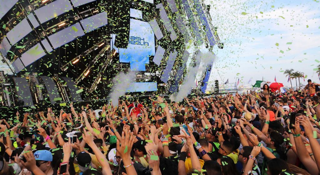 wide shot of people partying at a rave festival with confetti falling